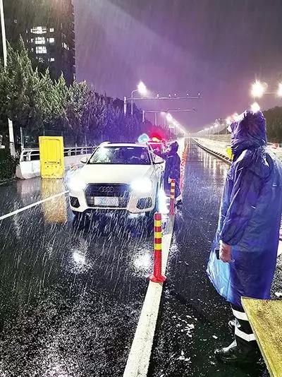 凌晨，東甌大橋卡點(diǎn)處，永嘉縣黨員干部頂風(fēng)冒雨、在嚴(yán)寒中牢牢值守。（　圖片由浙江省溫州市委組織部提供）